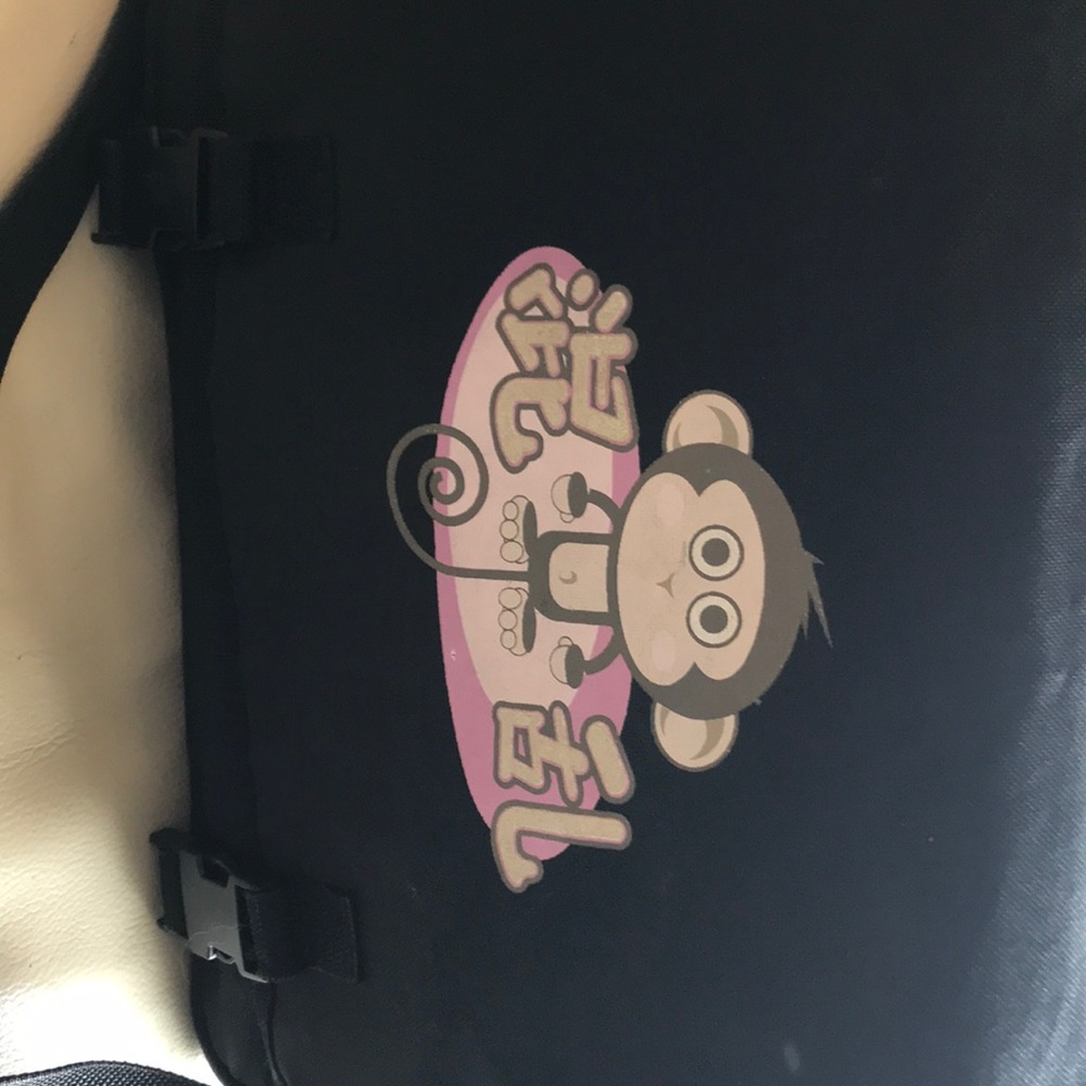 Tilt brand messenger bag with monkey detail.